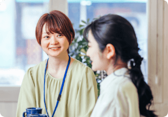 オフィス内で楽しそうに会話している二人の女性